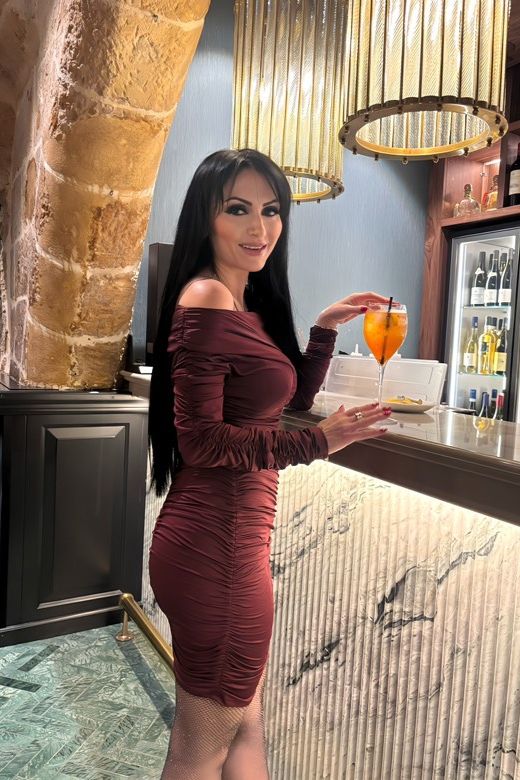 Woman wearing a figure flattering Alessandra Long Sleeve Wrap Bodycon Mini Dress - Classic Black BODYCON COLLECTION