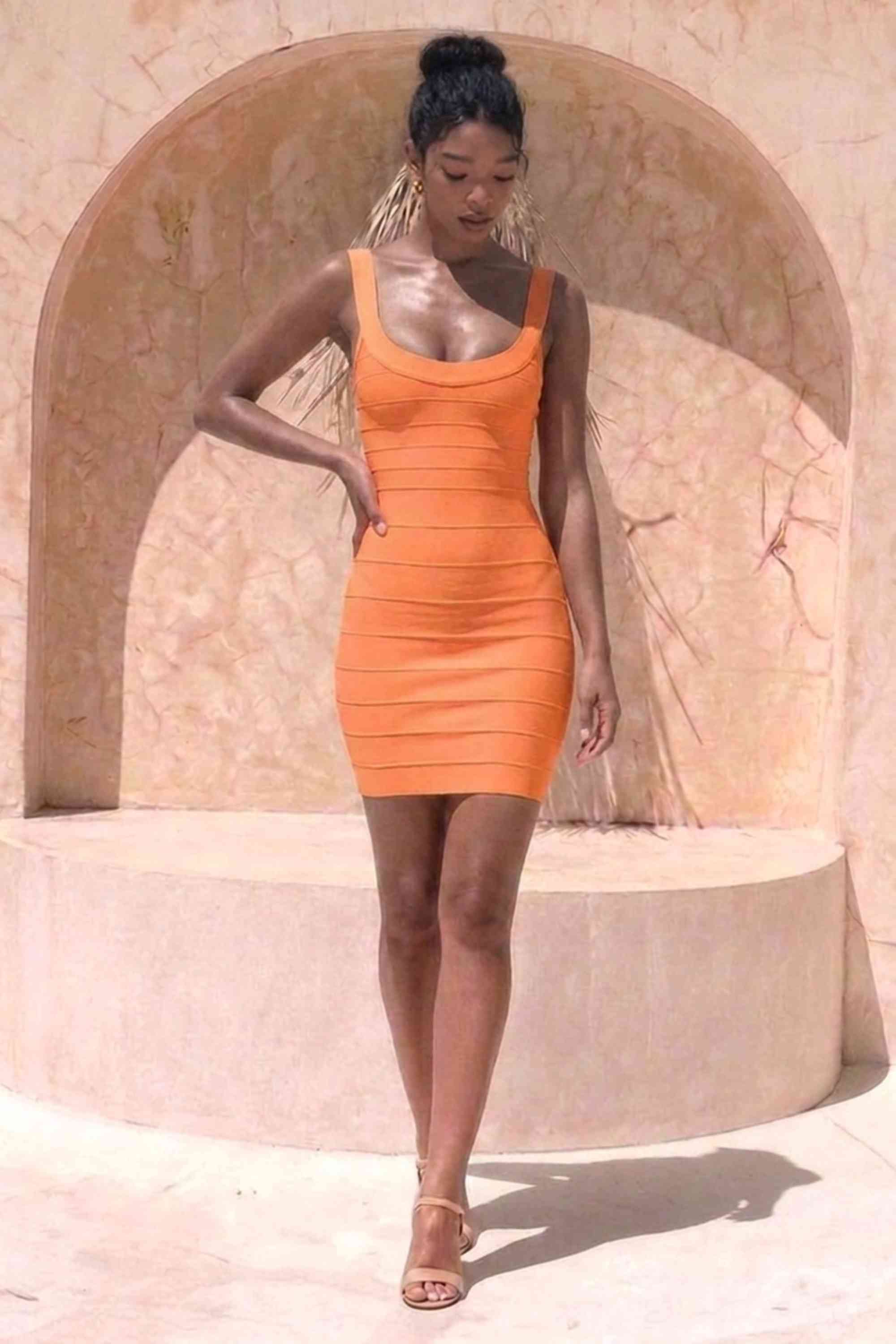 Woman wearing a figure flattering Cindy Bandage Mini Dress - Apricot Orange BODYCON COLLECTION Pty Ltd