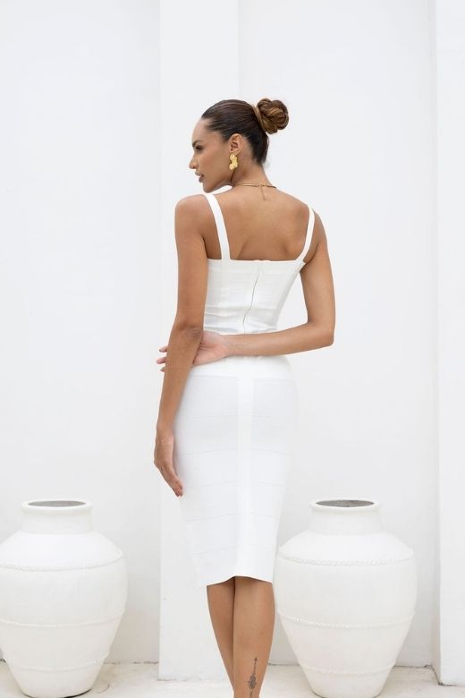 Woman wearing a figure flattering Heidi Bandage Midi Dress - White Pearl Bodycon Collection