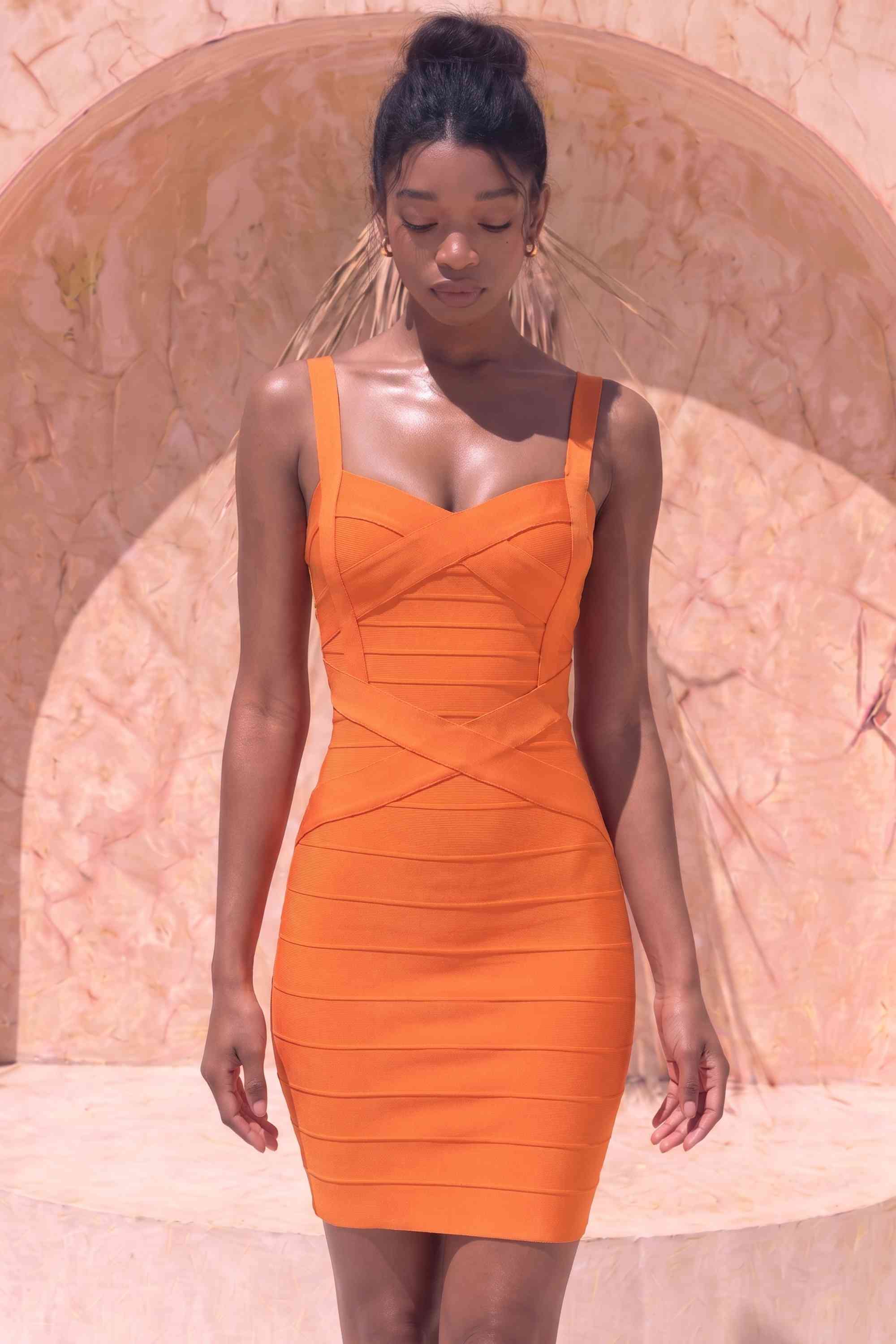 Woman wearing a figure flattering Heidi Bandage Mini Dress - Apricot Orange Bodycon Collection