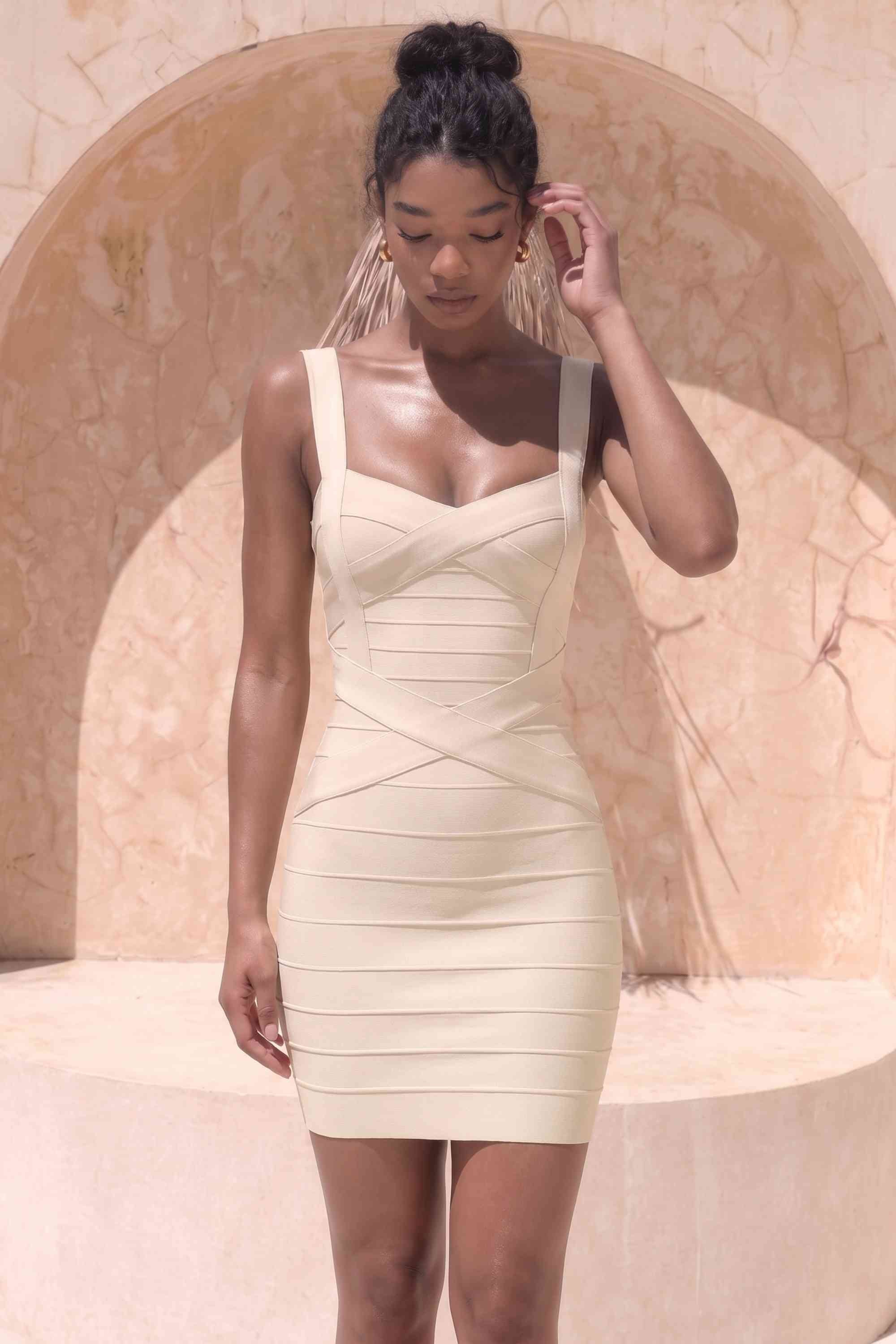 Woman wearing a figure flattering Heidi Bandage Mini Dress - Cream Bodycon Collection