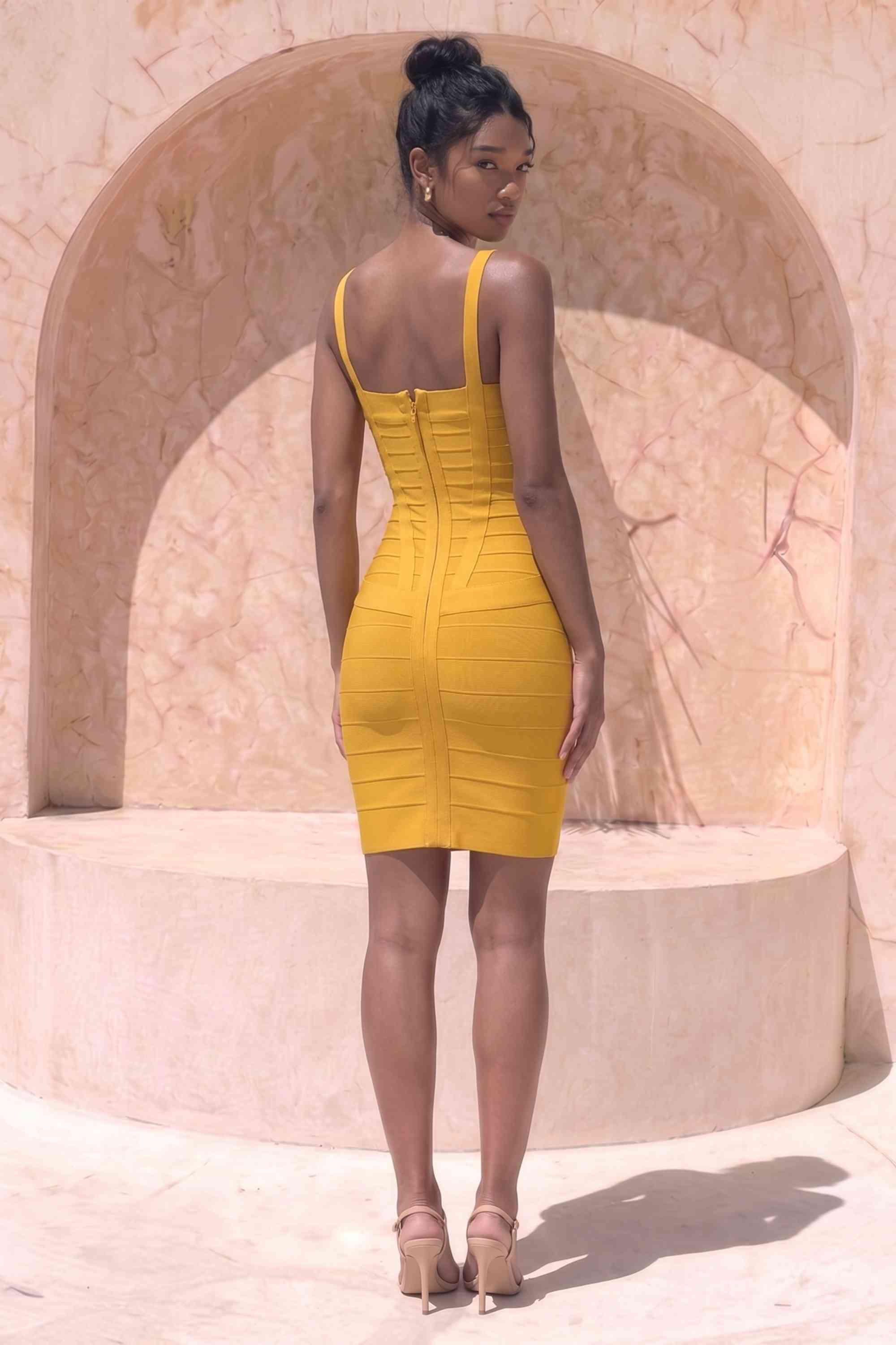 Woman wearing a figure flattering Heidi Bandage Mini Dress - Mustard Yellow Bodycon Collection