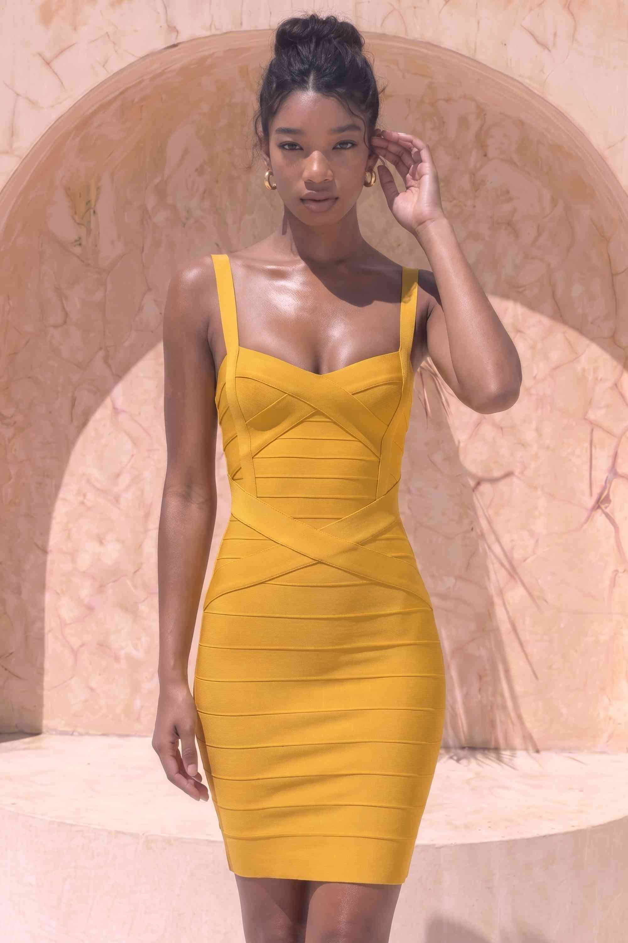 Woman wearing a figure flattering Heidi Bandage Mini Dress - Mustard Yellow Bodycon Collection
