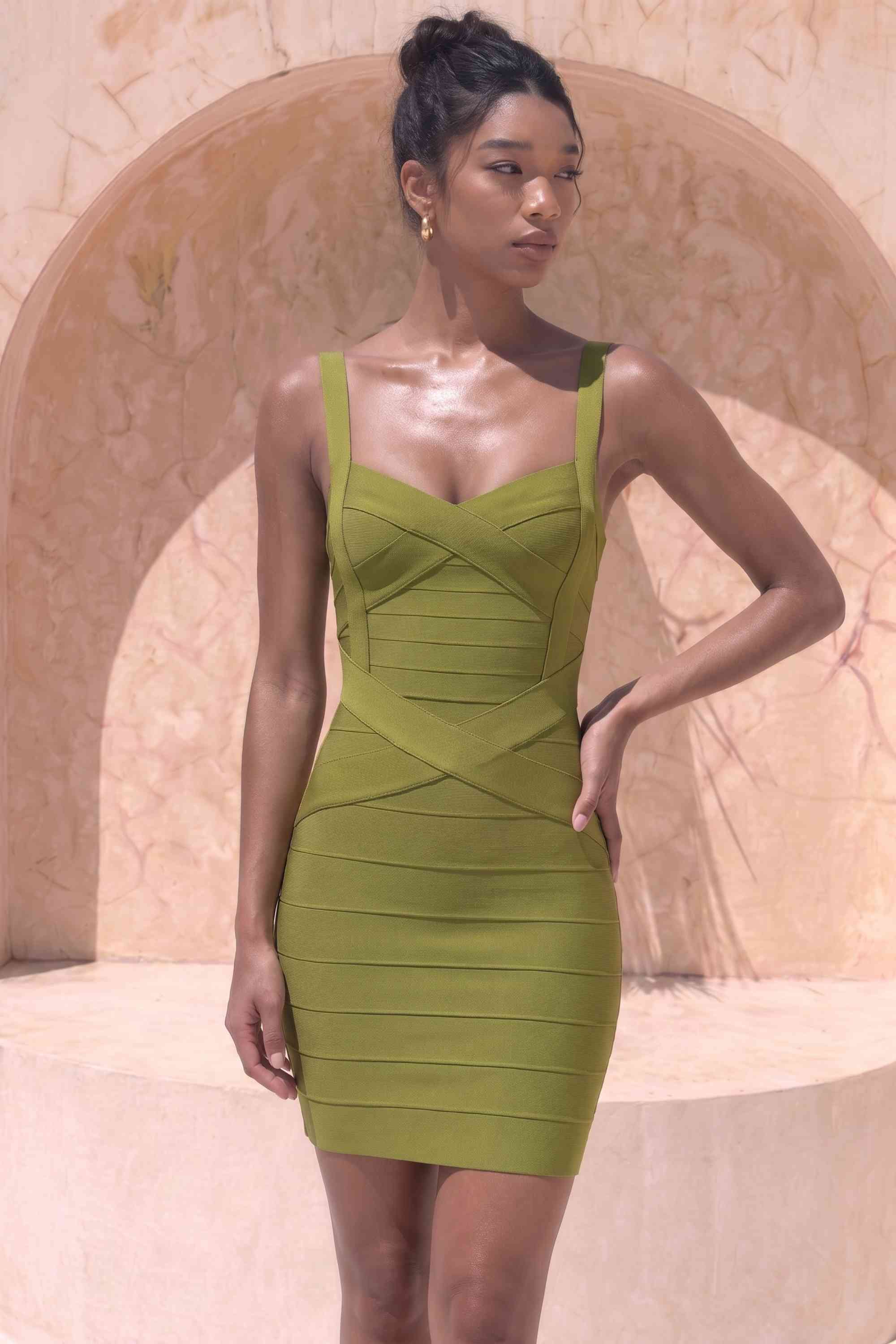 Woman wearing a figure flattering Heidi Bandage Mini Dress - Olive Green Bodycon Collection