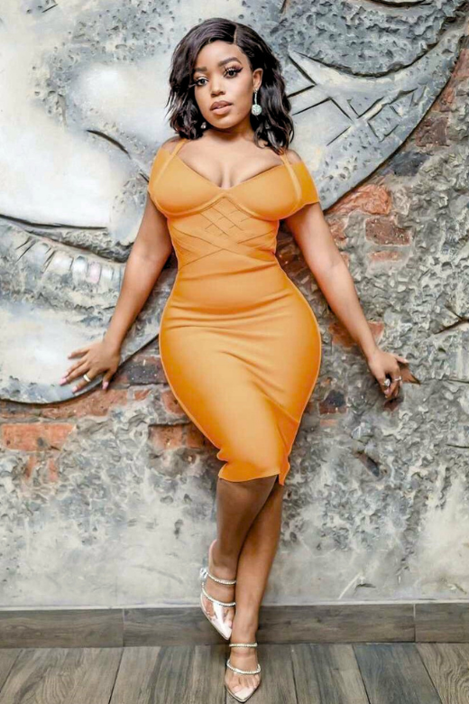 Woman wearing a figure flattering Leo Bandage Midi Dress - Apricot Orange Bodycon Collection
