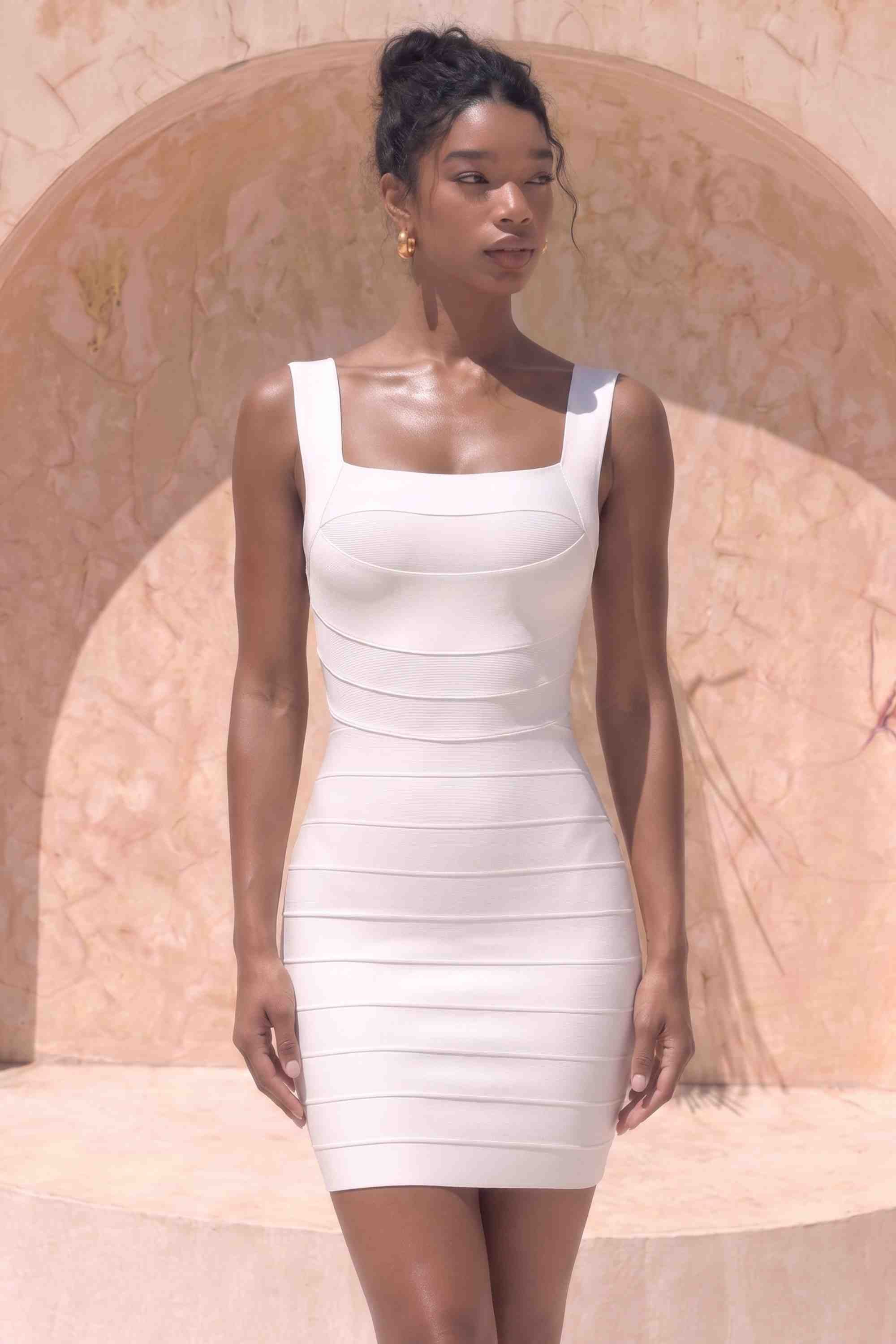 Woman wearing a figure flattering Madelyn Bandage Mini Dress - White Pearl BODYCON COLLECTION Pty Ltd