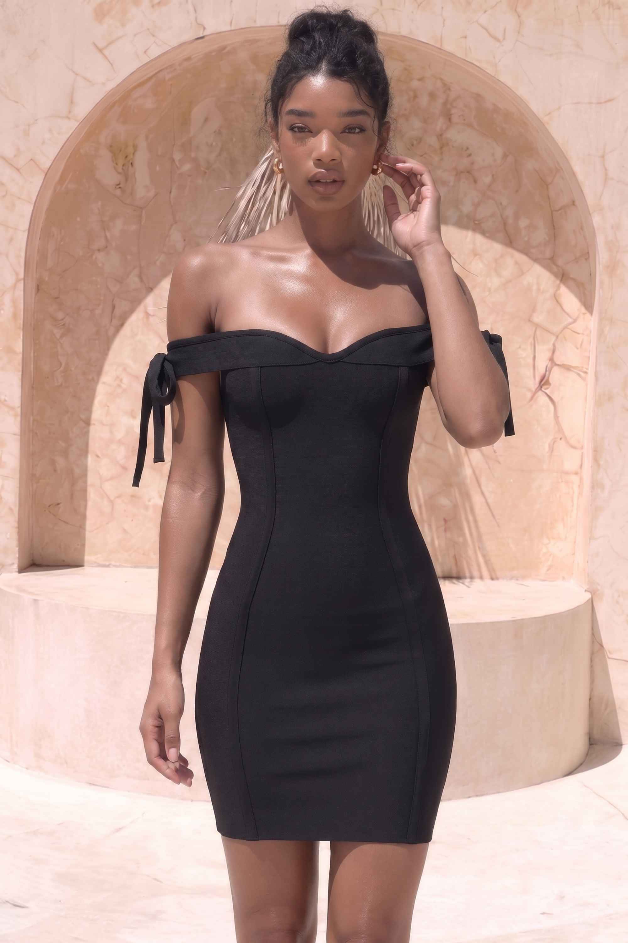 Woman wearing a figure flattering Penelope Bandage Mini Dress - Classic Black BODYCON COLLECTION