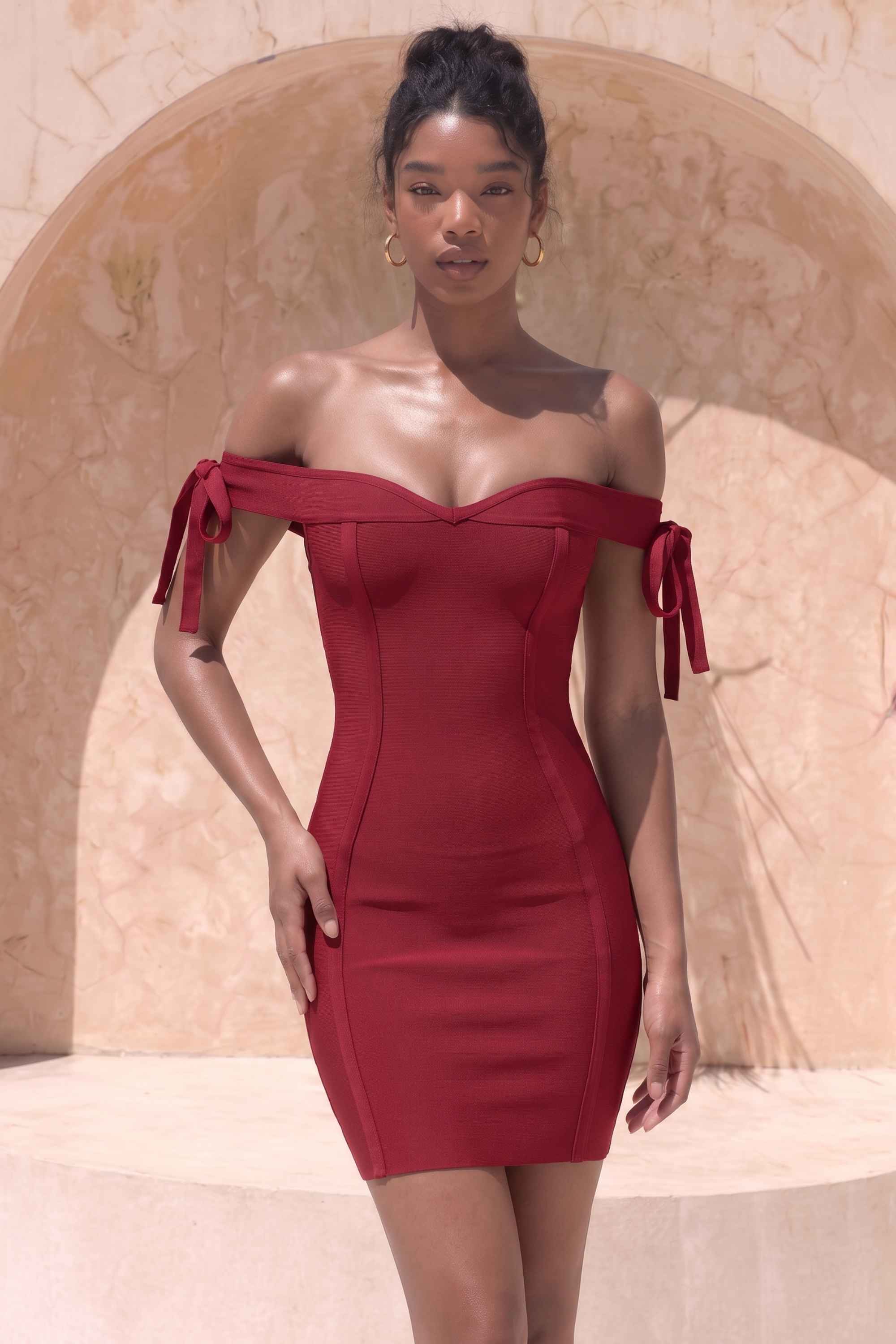 Woman wearing a figure flattering Penelope Bandage Mini Dress - Red Wine BODYCON COLLECTION
