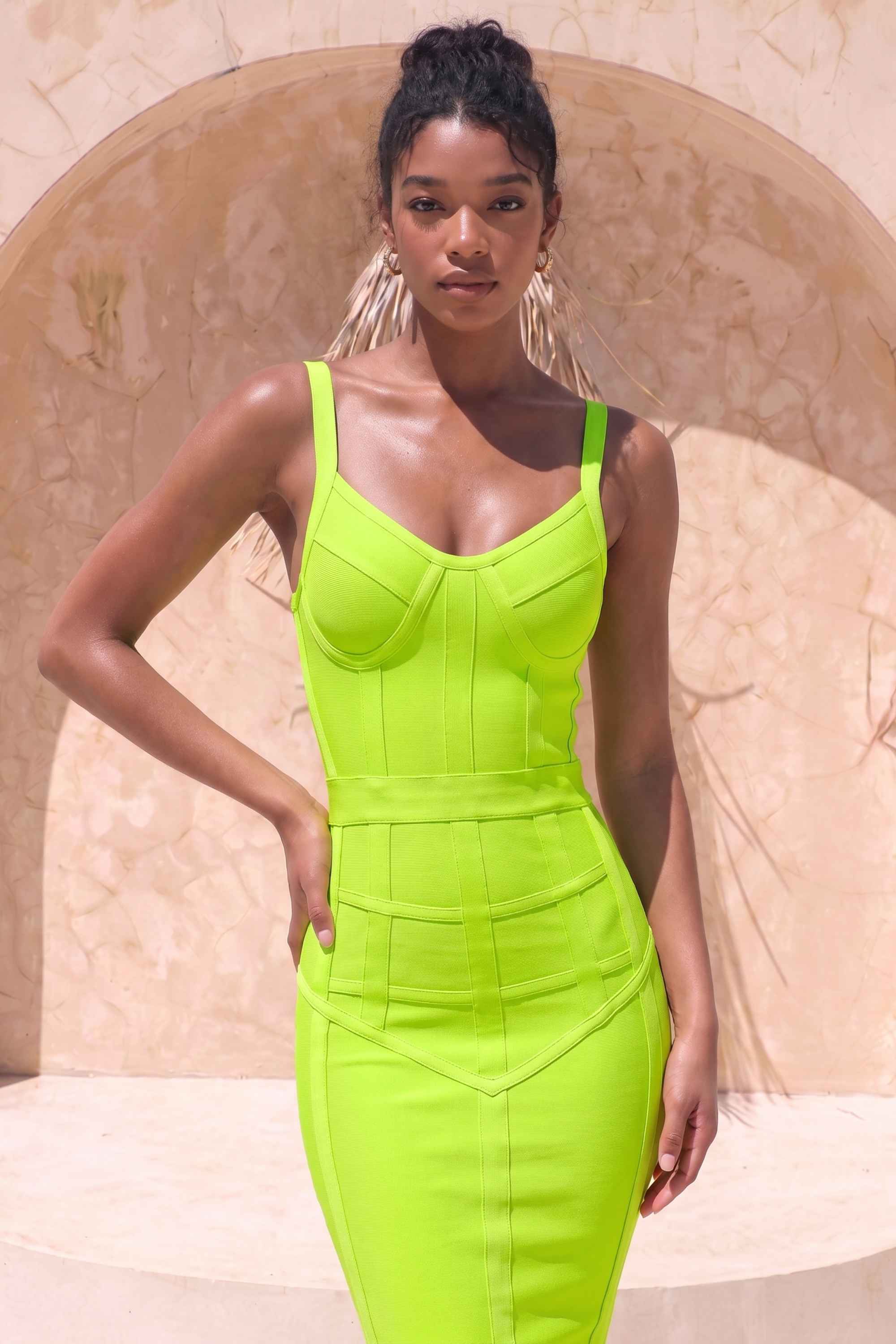 Woman wearing a figure flattering Pip Bandage Corset Dress - Neon Green Bodycon Collection