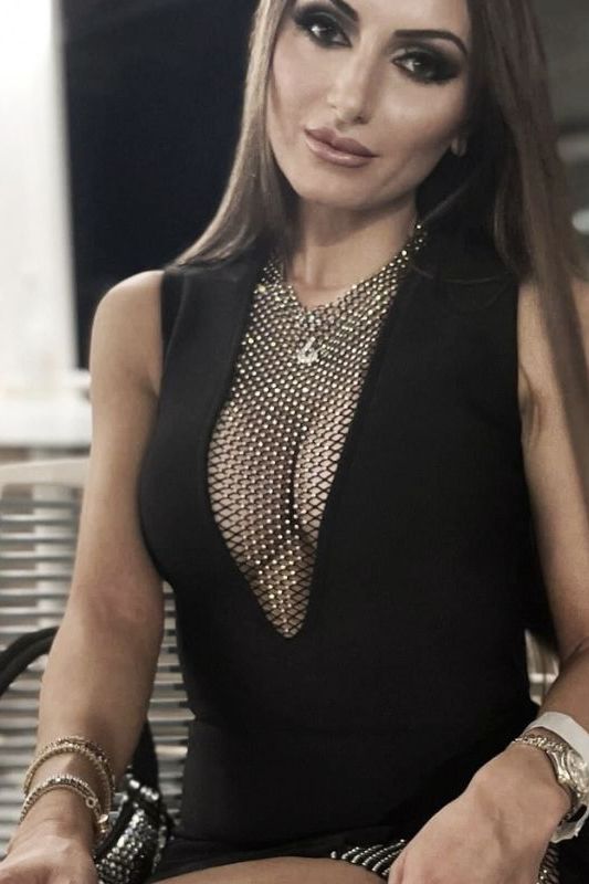 Woman wearing a figure flattering Sofie Bodycon Mini Dress - Classic Black BODYCON COLLECTION