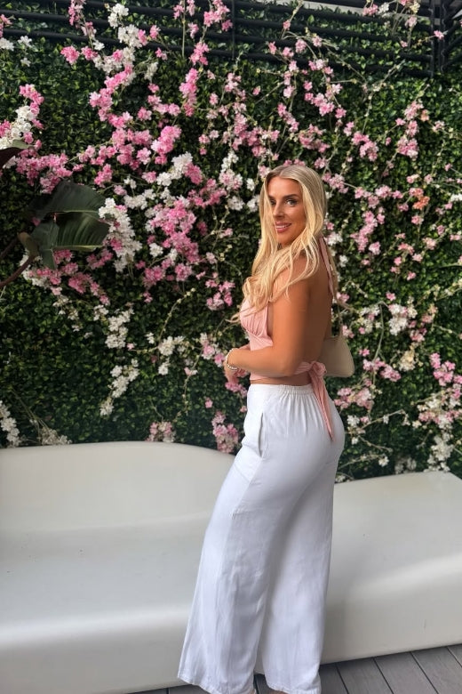 Woman wearing a figure flattering  Aby Halter Top - Pink Peach Fuzz BODYCON COLLECTION Pty Ltd