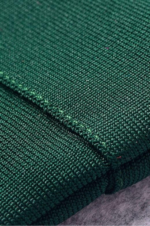 Woman wearing a figure flattering  Josie Bandage V Neck Mini Dress - Emerald Green BODYCON COLLECTION