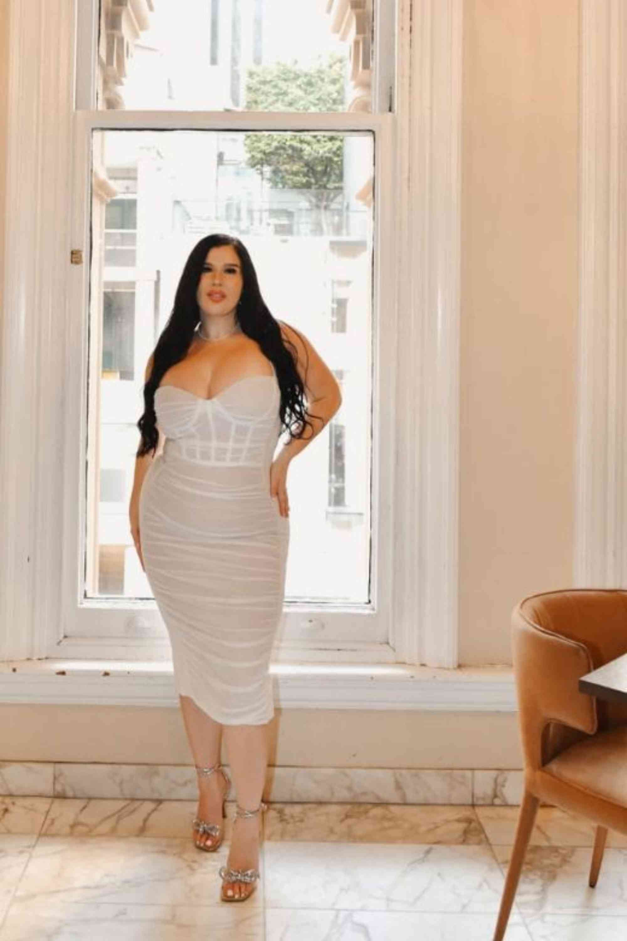 Woman wearing a figure flattering  Marilyn Bodycon Wrap Midi Dress - Classic Black BODYCON COLLECTION