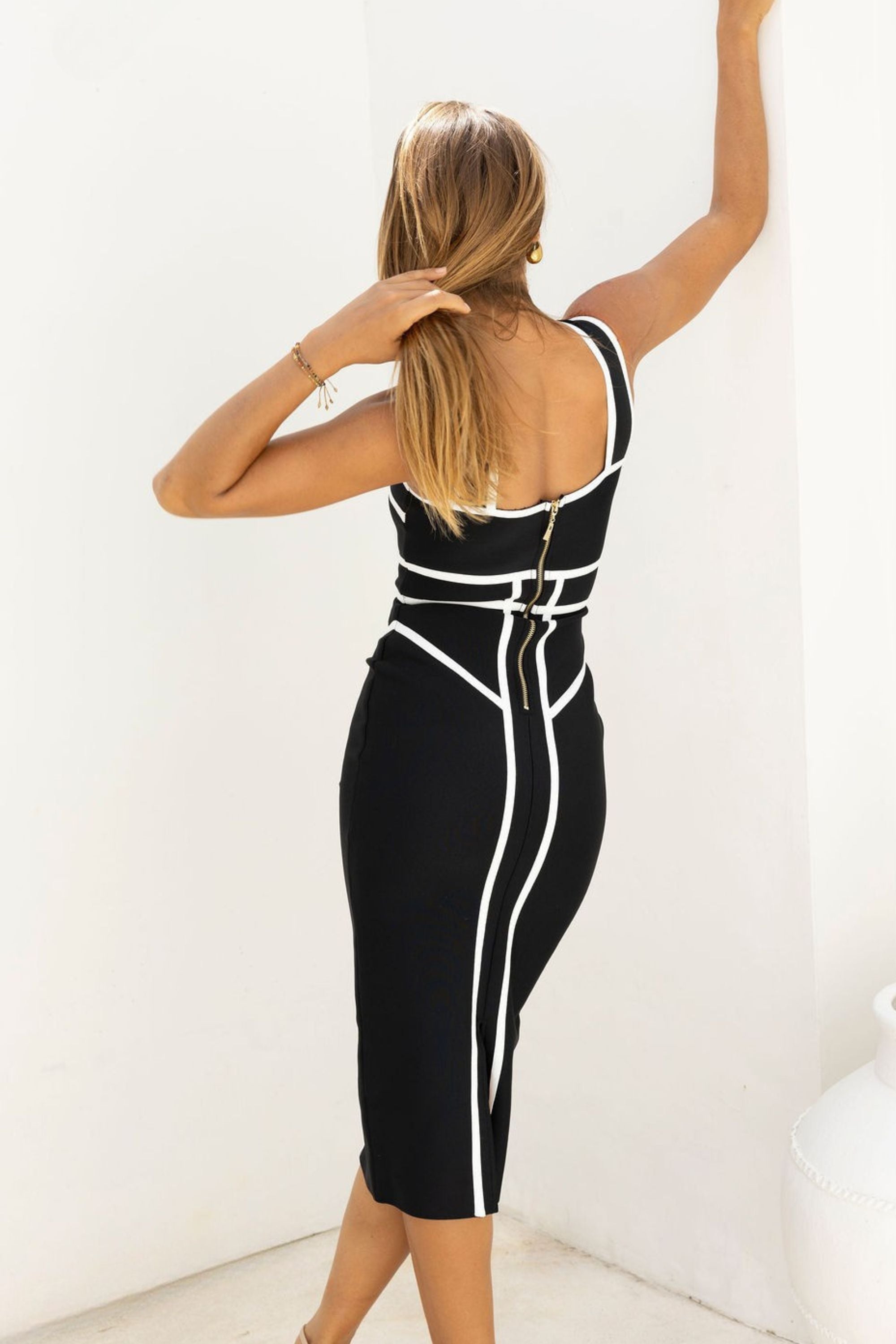 Woman wearing a figure flattering  Suki Bandage Midi Dress - Classic Black BODYCON COLLECTION